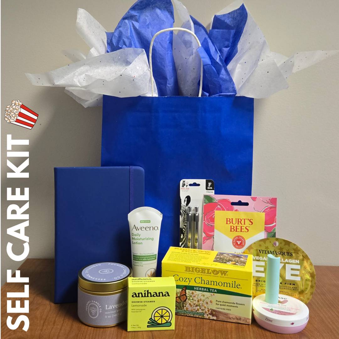 blue journal, pens, candle, shower steamer, face mask, under eye mask, lip balm, lotion, tea, hand cream